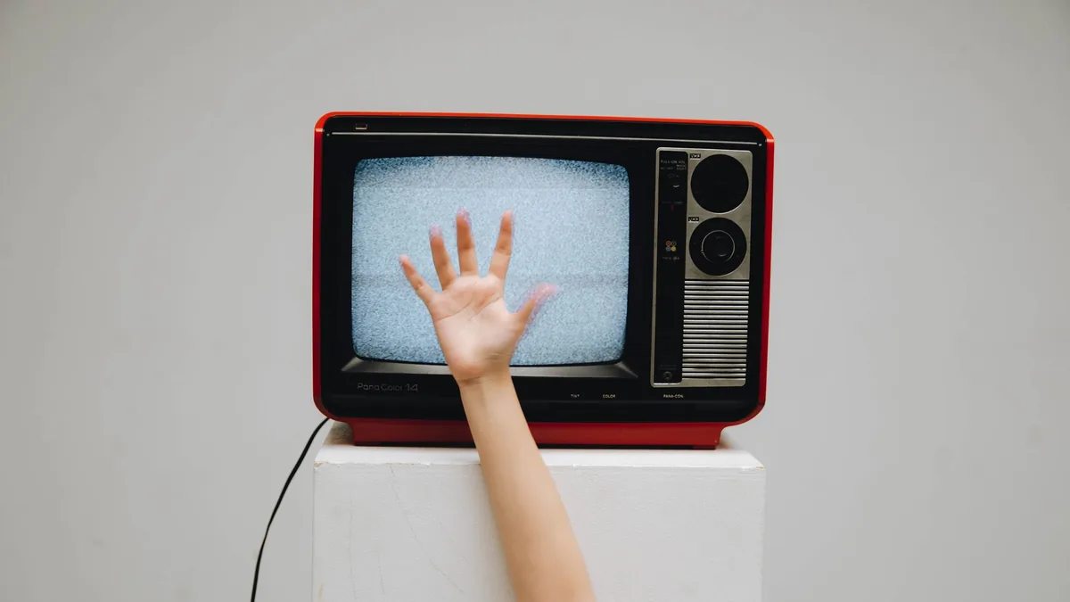 Set-top box Vodafone TV cu telecomandă, conectat la un televizor într-un living modern.